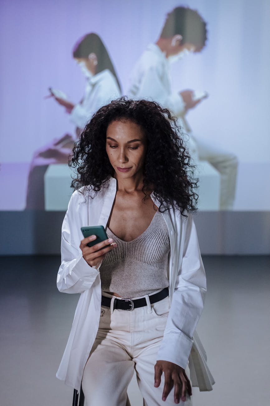 sitting woman in lab coat using smartphone